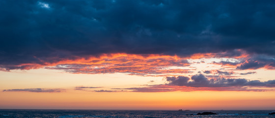 Fototapeta premium Wide sunset sky with vivid colors over ocean