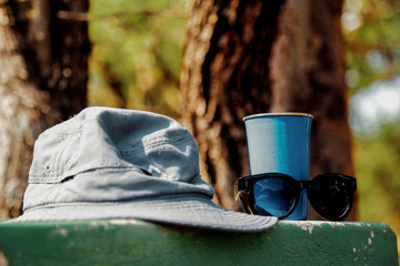 an olive hat with blue cup and sunglasses