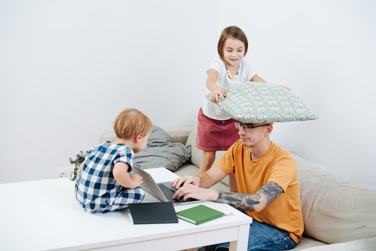Man working at home during isolation, while his kids trying to set him off