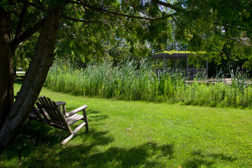 Wooden Adirondack chairs overlooking the pond in the grape vineyard at Ontario, Canada.