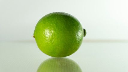 The full lime has a reflection on the ground.