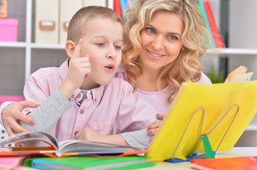 Fototapeta premium Mother with her son doing homework at home