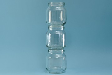 Vertical row of glass jars in the center on a blue background.