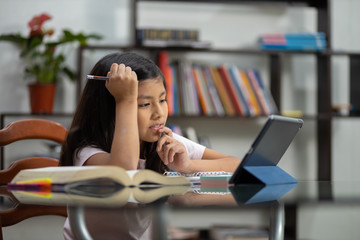 Mexican girl studying online with tablet at home concentrated due to quarantine, homeschool 