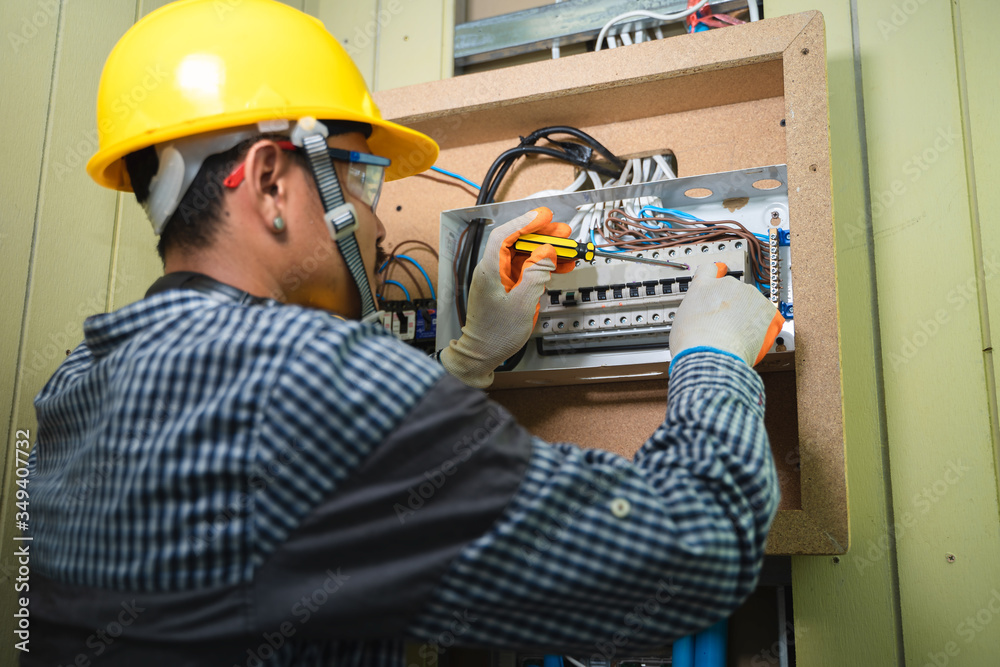 Aufkleber Electrician Installing Socket In New House,Electrician working safely on switches and sockets of a residential electrical system.