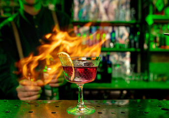 Close up of alcoholic cocktail, beverage, drink, prepared by professional barman in multicolored neon light. Entertainment, drinks, service concept. Modern bar, trendy neoned colors, copyspace.