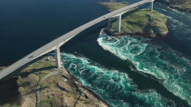 Aerial view of the famous Saltstaumen strait in Norway. When tide carrying 
a huge mass of water out of the bay, whirlpools and eddies forming in the turquoise water, white foam rising to the surface.
