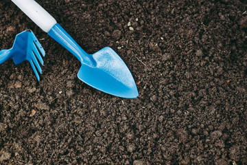 Agricultural equipment shovel and harrow on dark wet soil ground