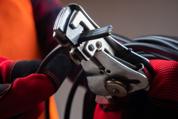 Crimping tool for wires. Crimper close-up. A person is holding a