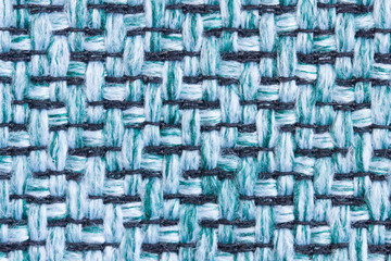 Background from the surface of the fabric in green and black in macro. Large weaving of threads of a sample of furniture upholstery.