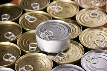 many cans of silver and gold colored tuna with in a close-up
