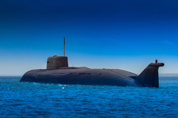 Submarine close-up. Nuclear submarine on a background of blue water and blue sky. Protection of the...