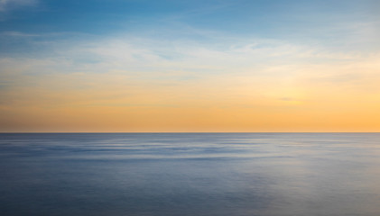 Naklejka na ściany i meble Sunset over the sea in long exposure mode.