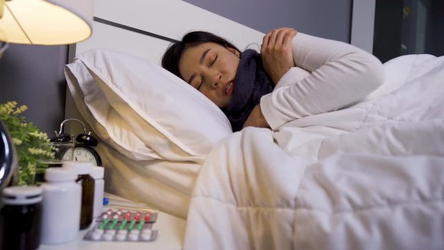 sick woman sleeping and feeling cold in a bed