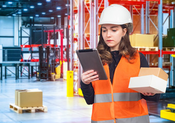 Girl enters parcel information into the tablet. Girl in uniform at the warehouse. Concept - stock inventory. Warehouse manager counts the remaining. Girl gives out goods from warehouse.