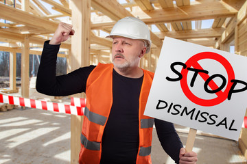 Protests against dismissal. Builder is outraged by dismissal of staff. Man with a banner. Man at a...