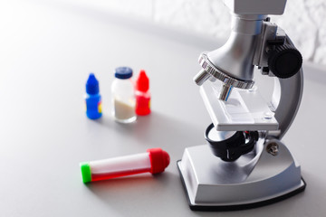 microscope with lab glassware, science laboratory research and development concept