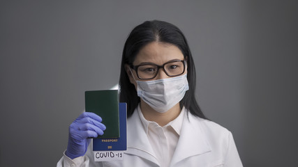 Female doctor holds a passport with the results of an express test for coronavirus. Closure of state borders due to the outbreak of coronavirus. Pandemic concept