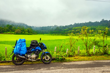 Fototapeta na wymiar Solo traveler loaded bike with isolated road and amazing background