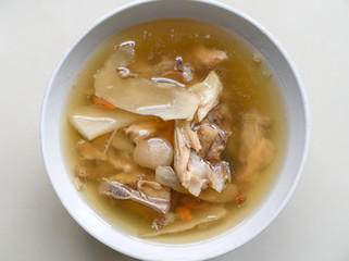 Chinese traditional american ginseng soup with chicken bones served in a bowl.