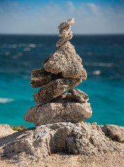 Pyramid of stones on the beach closeup. Sea horizon background. balance concept