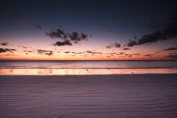 Obraz premium Beautiful orange sunrise over the ocean in far north Queensland, white sandy beach