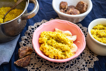 Yellow cooked millet grain cereal porridge for breakfast