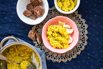 Yellow cooked millet grain cereal porridge for breakfast