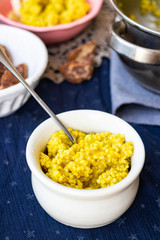 Yellow cooked millet grain cereal porridge for breakfast