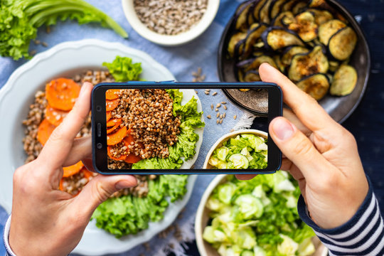 Phone vegan food photography. Make smartphone photo of buckwheat porridge lunch. Create blogging content on kitchen table.