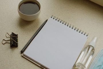 Close up photo of blank note pad, antiseptic, mask and cup of copy on white background. New year Concept - 2021. Place for text