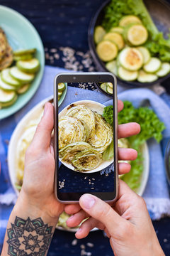 Phone vegan food photography. Make smartphone photo of baked, roasted cabbage. Create blogging content on kitchen table.