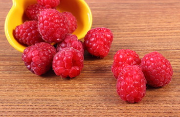 Fresh raspberries in bowl on wooden board, healthy food
