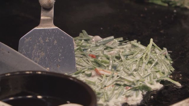 Bindae-tteok in Gukje International Market Busan city. Bindaetteok, fried buchimgae, savory pancake with ground mung beans, vegetables, meat. Korean vendors selling food in street, South Korea