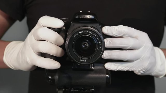 hands with white latex gloves taking photo camera to prevent contagion