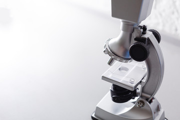 microscope stands on a table on a white background