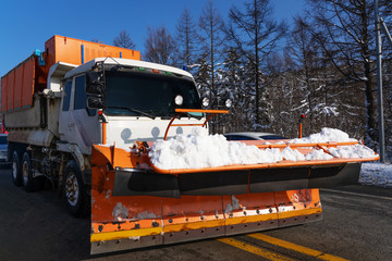 Orange Trucks Snow Plows with forest tree background