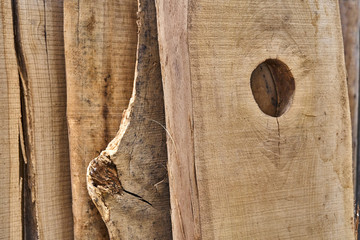 Knot holes in a oak board. Unedged oak lumber. Wooden texture. Close-up