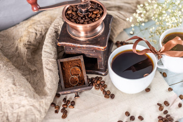 Cups of black coffee. Wedding rings in a drawer of the coffee grinder with coffee powder. Proposals to get married