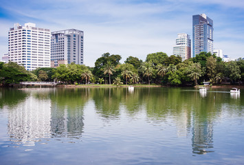 Obraz premium Palmy i drapacze chmur w pobliżu jeziora. Widok z drugiej strony jeziora.