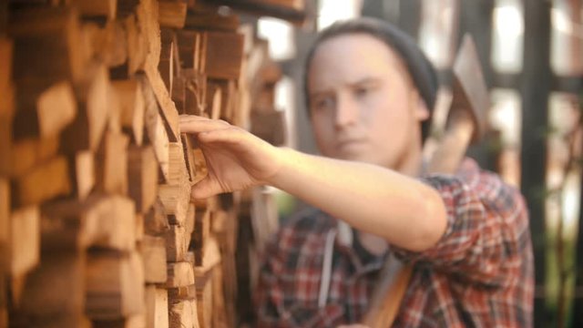 Man woodcutter with ax puts out the log from the stand