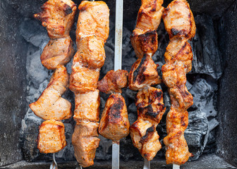 A close-up of the pies of pork in teriyaki sauce is fried  on skewers. Preparation of a shish kebab on a summer day