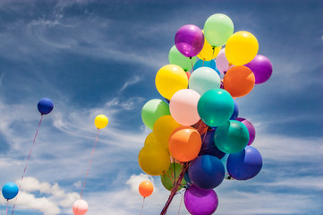 Colorful balloons against a sunny blue sky