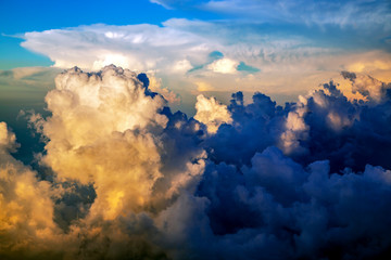 View from above on beautiful sunset sky with stormy clouds with airplane.