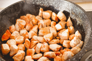 Sliced fried chicken in a black pan.
