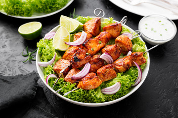 Kebabs - grilled chicken meat skewers, shish kebab with green salad leaves.