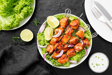 Kebabs - grilled chicken meat skewers, shish kebab with green salad leaves. © Nelea Reazanteva