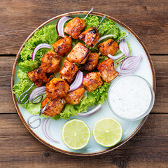 Kebabs - grilled chicken meat skewers, shish kebab with green salad leaves.