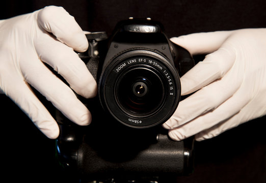 hands with white latex gloves taking photo camera to prevent contagion