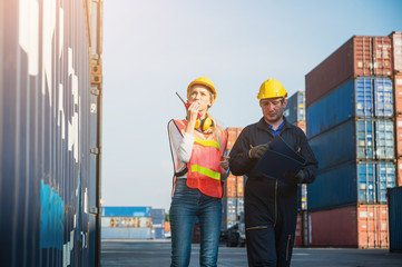 Two foreman man & woman worker working checking at Container cargo harbor to loading containers. Dock male and female staff business Logistics import export shipping concept.
